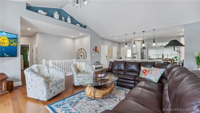 living room with vaulted ceiling and light wood-type flooring