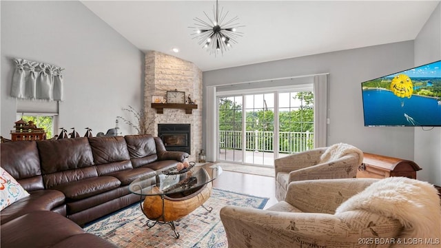 living room featuring lofted ceiling, a chandelier, and a fireplace