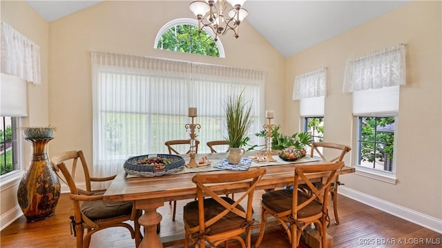 dining space featuring high vaulted ceiling, an inviting chandelier, and dark hardwood / wood-style flooring