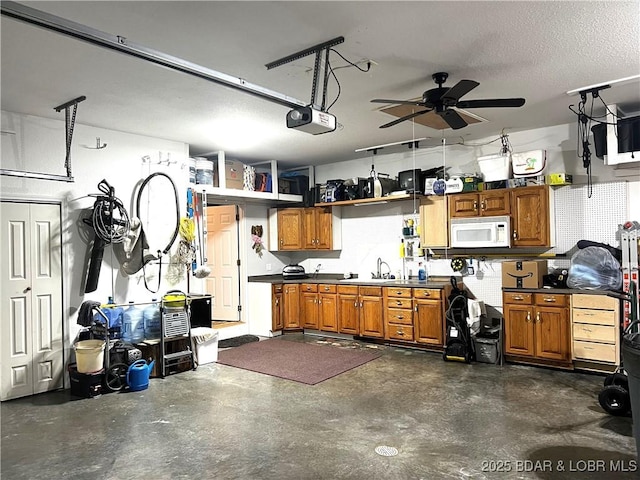 garage with sink, a garage door opener, and ceiling fan