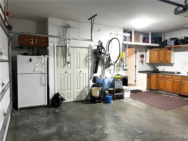 garage with sink, a garage door opener, and white fridge