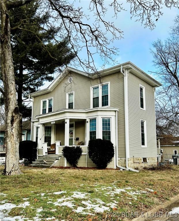 view of front of house with a front yard and covered porch