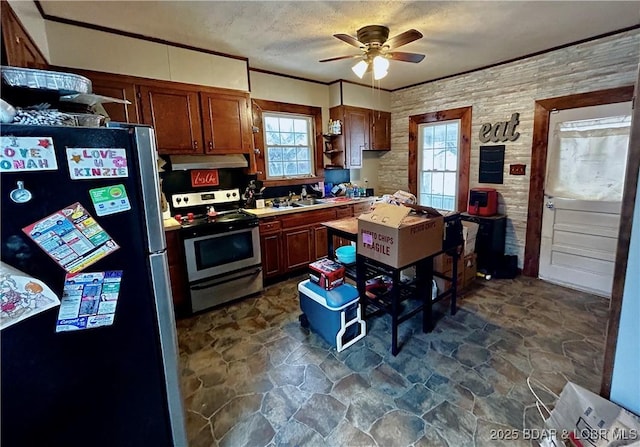 kitchen featuring appliances with stainless steel finishes, sink, ceiling fan, crown molding, and a textured ceiling