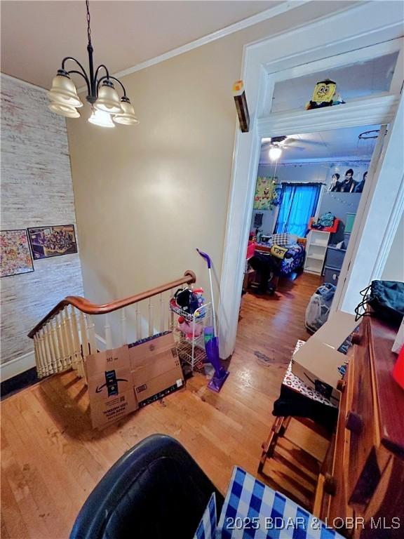 interior space with crown molding, wood-type flooring, and a chandelier