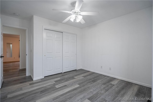 unfurnished bedroom featuring hardwood / wood-style floors, ceiling fan, and a closet