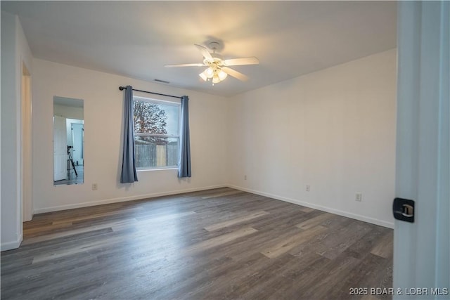 empty room with dark wood-type flooring and ceiling fan