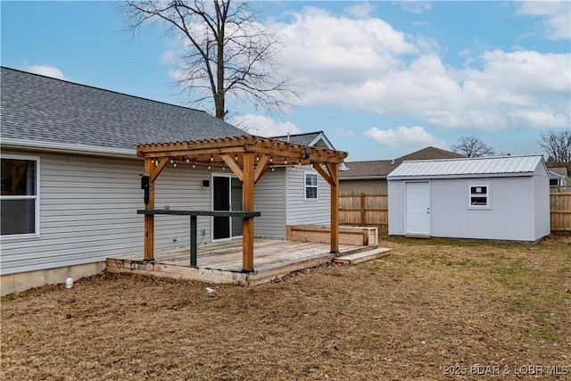 rear view of property featuring a wooden deck, a yard, a pergola, and a shed