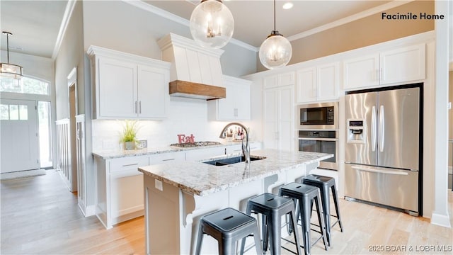 kitchen with white cabinetry, sink, a kitchen island with sink, and appliances with stainless steel finishes