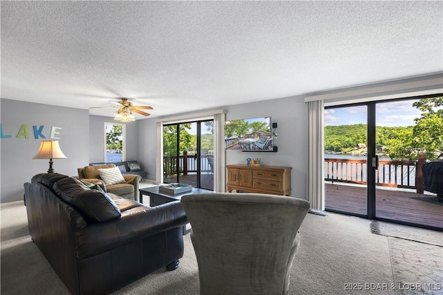 carpeted living room featuring ceiling fan and a textured ceiling