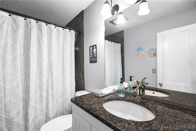 bathroom featuring vanity, a textured ceiling, and toilet