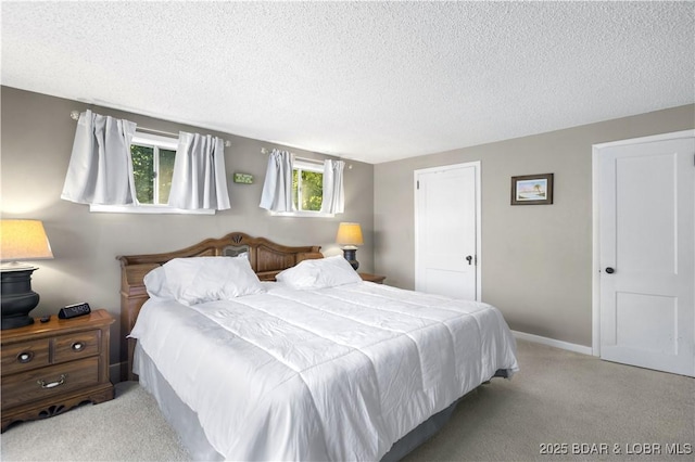 bedroom featuring light colored carpet and a textured ceiling