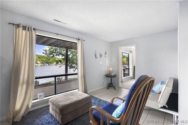 interior space featuring a textured ceiling and a water view