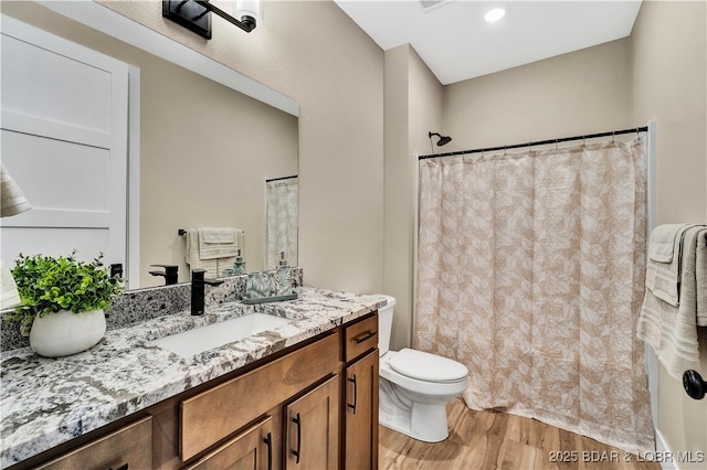 bathroom featuring hardwood / wood-style flooring, vanity, and toilet