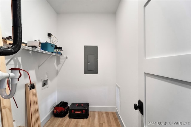 laundry room featuring electric panel, hookup for a washing machine, and light wood-type flooring