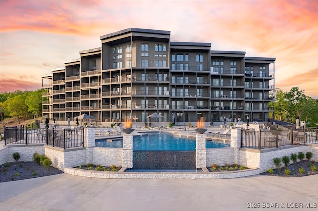 outdoor building at dusk featuring a community pool