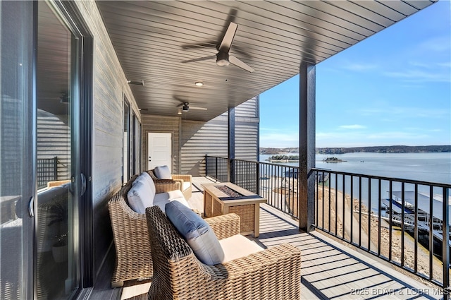 balcony featuring a water view, ceiling fan, and an outdoor fire pit