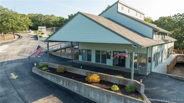 exterior space featuring a carport and roof with shingles