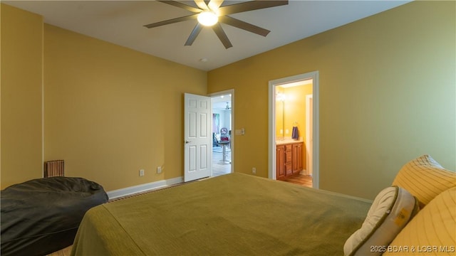 bedroom featuring ceiling fan, light colored carpet, and connected bathroom