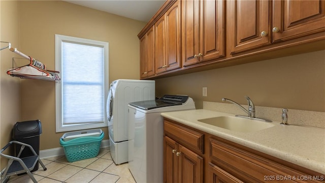 laundry room with cabinets, sink, light tile patterned floors, and washer and clothes dryer