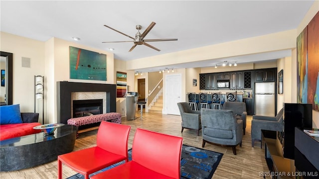 living room featuring ceiling fan, track lighting, and light wood-type flooring