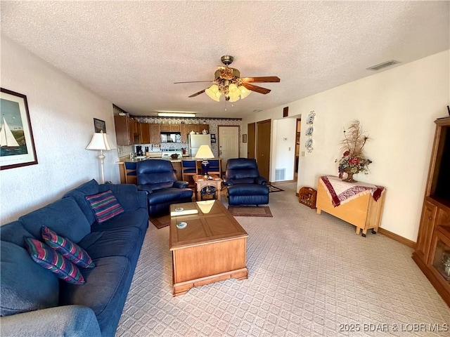 living room featuring ceiling fan and a textured ceiling