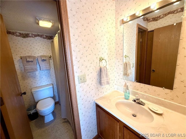 bathroom with walk in shower, toilet, a textured ceiling, vanity, and tile patterned flooring