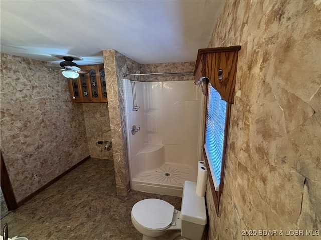 bathroom with toilet, ceiling fan, and walk in shower