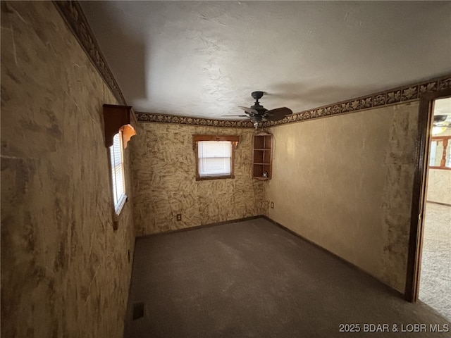 carpeted spare room with ceiling fan