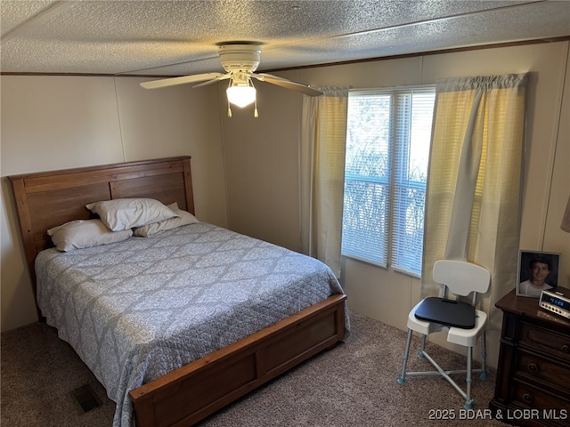 bedroom featuring ceiling fan, carpet floors, and a textured ceiling