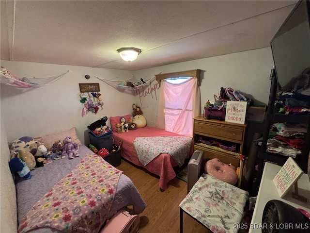 bedroom with hardwood / wood-style flooring and a textured ceiling