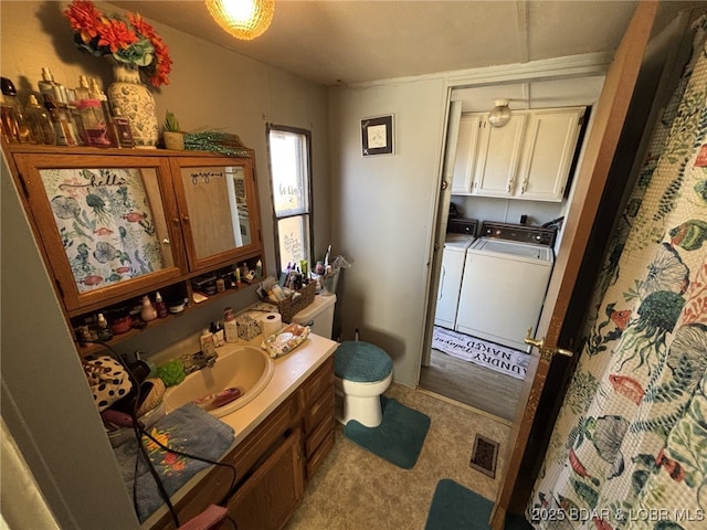 bathroom with vanity, independent washer and dryer, and toilet