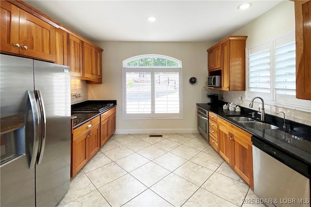 kitchen with tasteful backsplash, sink, stainless steel appliances, and a healthy amount of sunlight