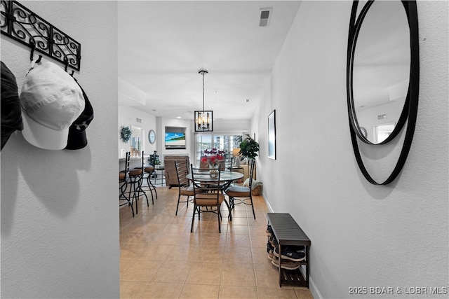 tiled dining space with a chandelier