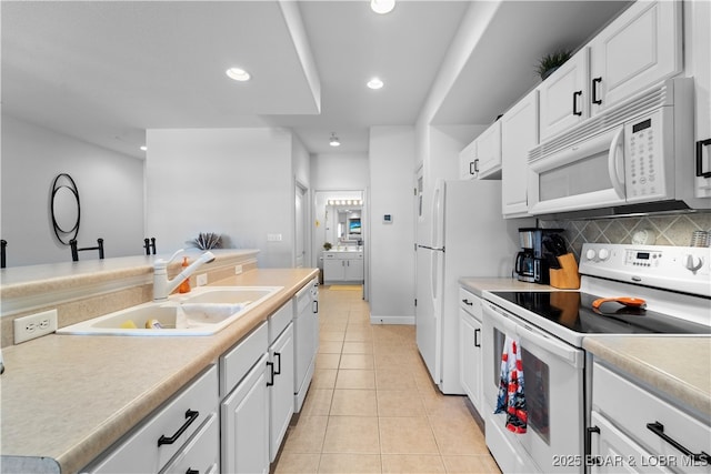 kitchen with white cabinetry, sink, white appliances, and light tile patterned floors