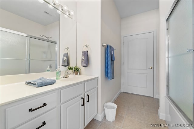 bathroom with a shower with door, vanity, and tile patterned floors