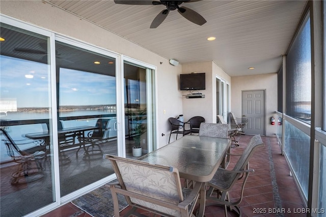 sunroom / solarium featuring a water view