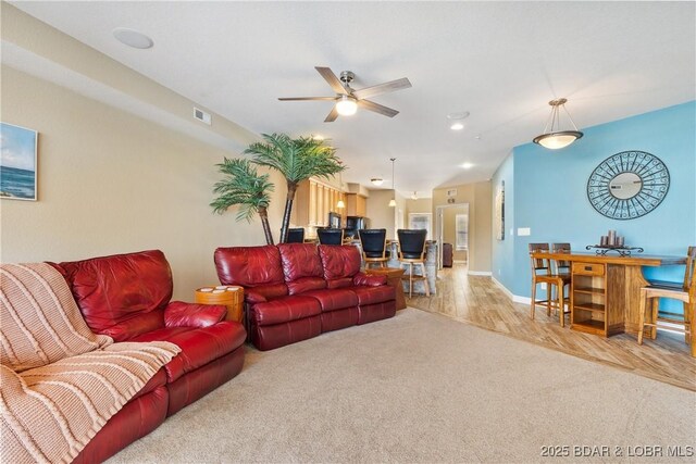 carpeted living room with ceiling fan