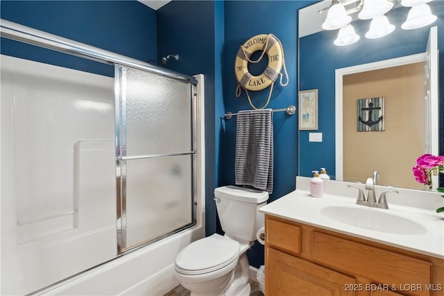 full bathroom featuring vanity, combined bath / shower with glass door, and toilet