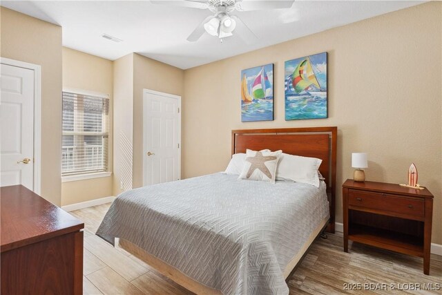 bedroom with light hardwood / wood-style floors and ceiling fan