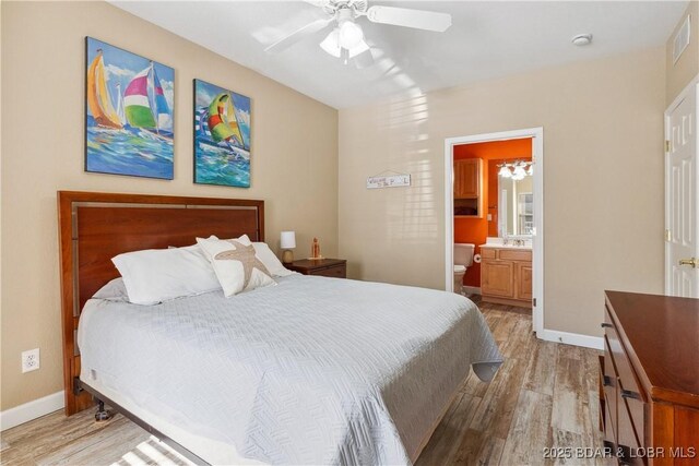 bedroom with connected bathroom, light hardwood / wood-style floors, and ceiling fan