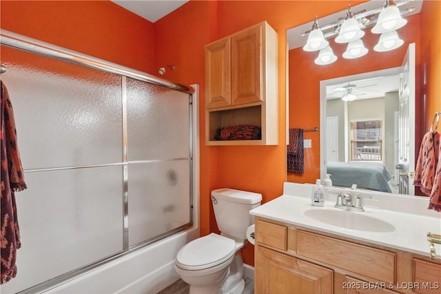 full bathroom featuring shower / bath combination with glass door, ceiling fan, vanity, and toilet