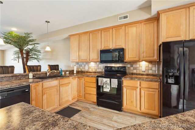 kitchen featuring sink, tasteful backsplash, pendant lighting, light hardwood / wood-style floors, and black appliances