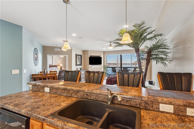 kitchen featuring hanging light fixtures, sink, dishwasher, and ceiling fan