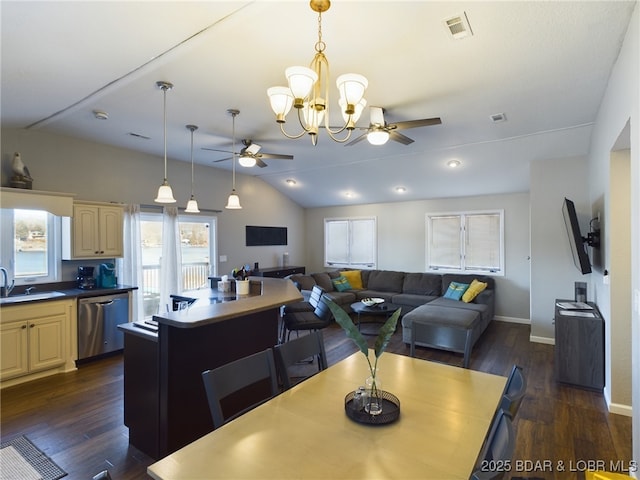 dining room featuring dark wood-type flooring, sink, ceiling fan with notable chandelier, and vaulted ceiling