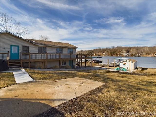 view of dock featuring a deck with water view and a yard