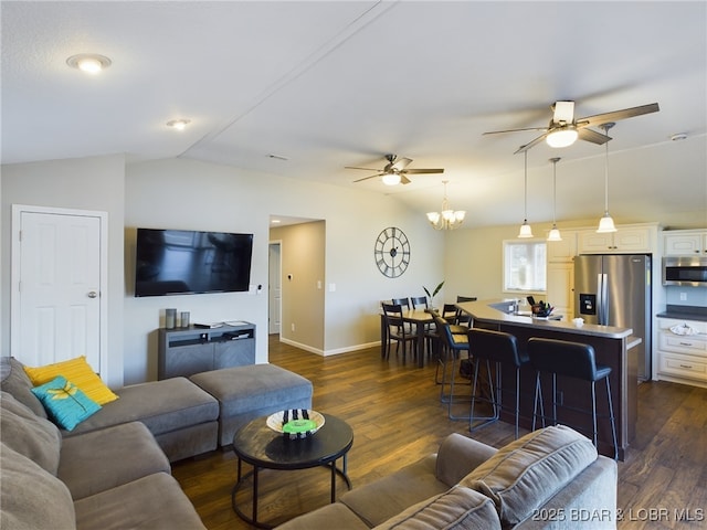 living room featuring lofted ceiling, dark wood-type flooring, and ceiling fan with notable chandelier