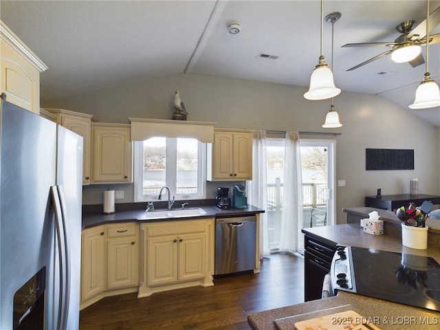 kitchen featuring lofted ceiling, sink, dark wood-type flooring, appliances with stainless steel finishes, and decorative light fixtures