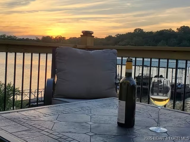 patio terrace at dusk featuring a water view