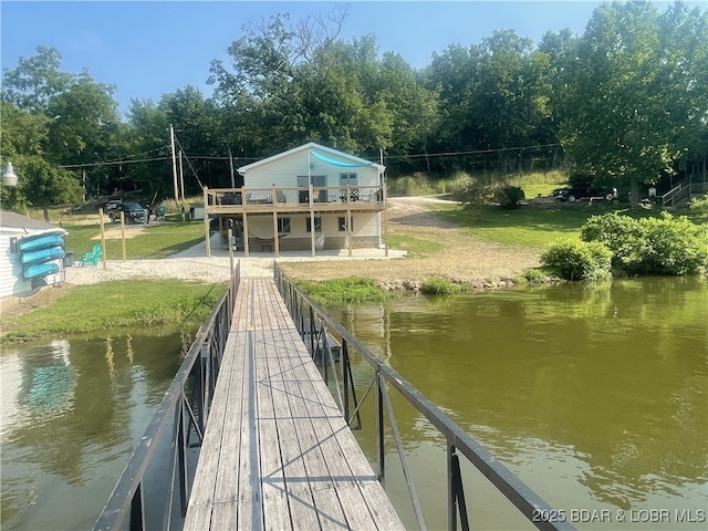 view of dock featuring a water view and a yard