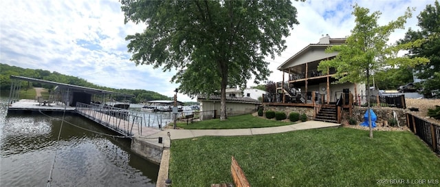 view of dock featuring a water view and a yard